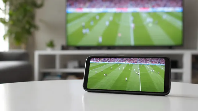 手機與電視上的同場足球直播畫面;AI 情境圖