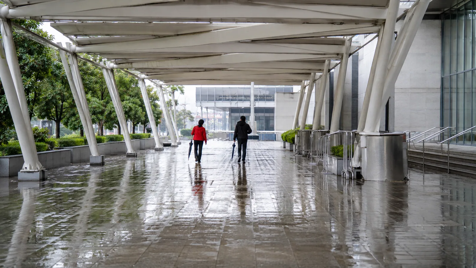 雨後場館外有遮簷的行人通道與濕潤地磚,AI 情境圖